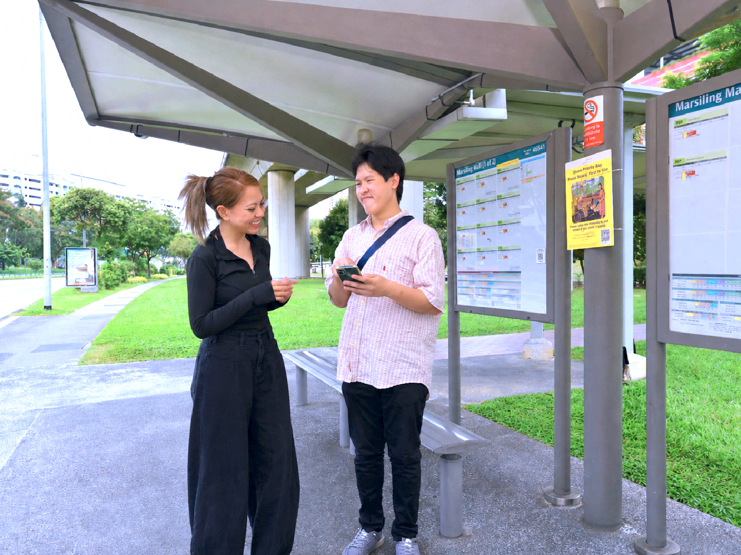 Joshua showing directions to a commuter at the bus stop